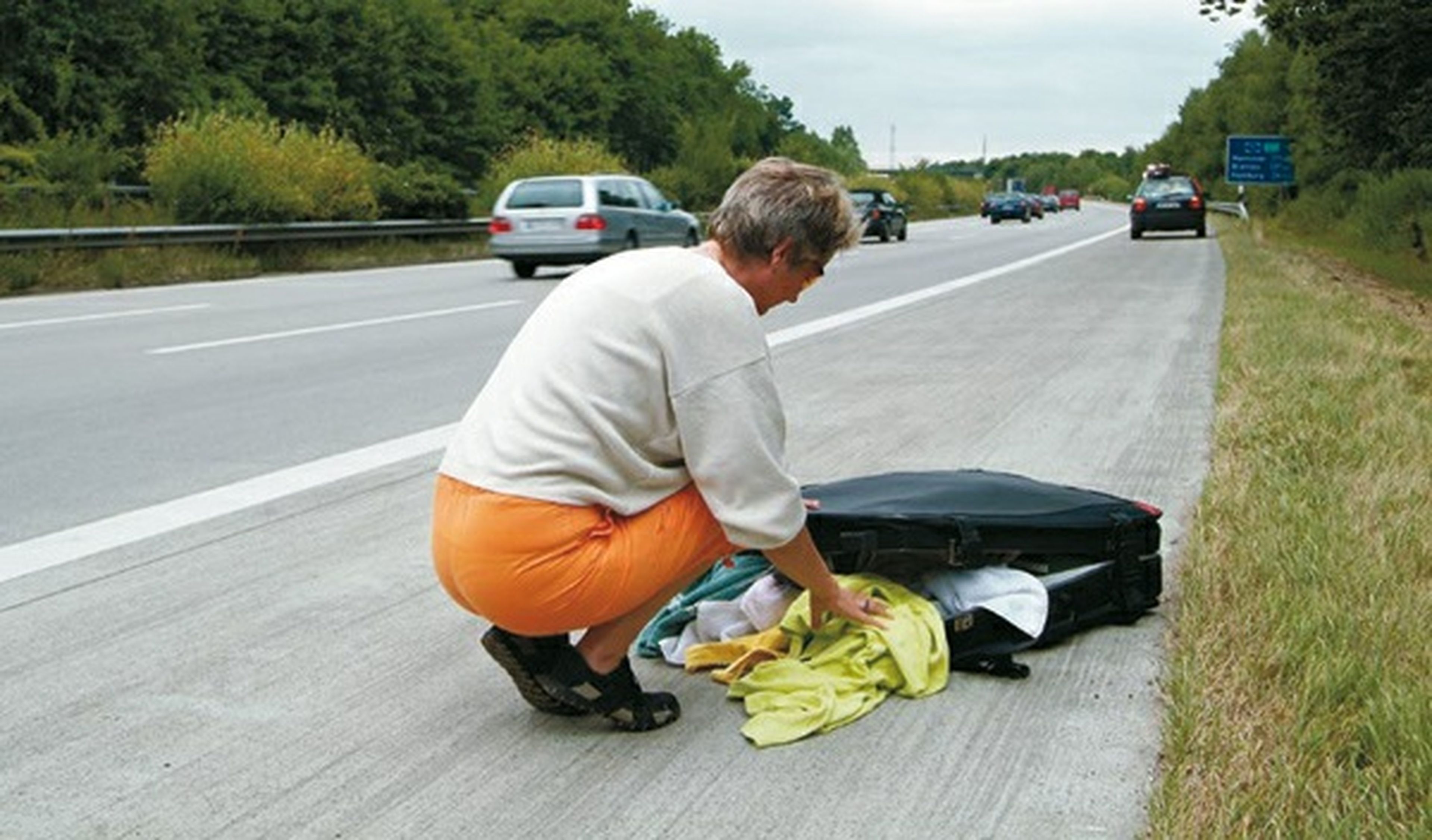 Mujer en la carretera colocando el equipaje