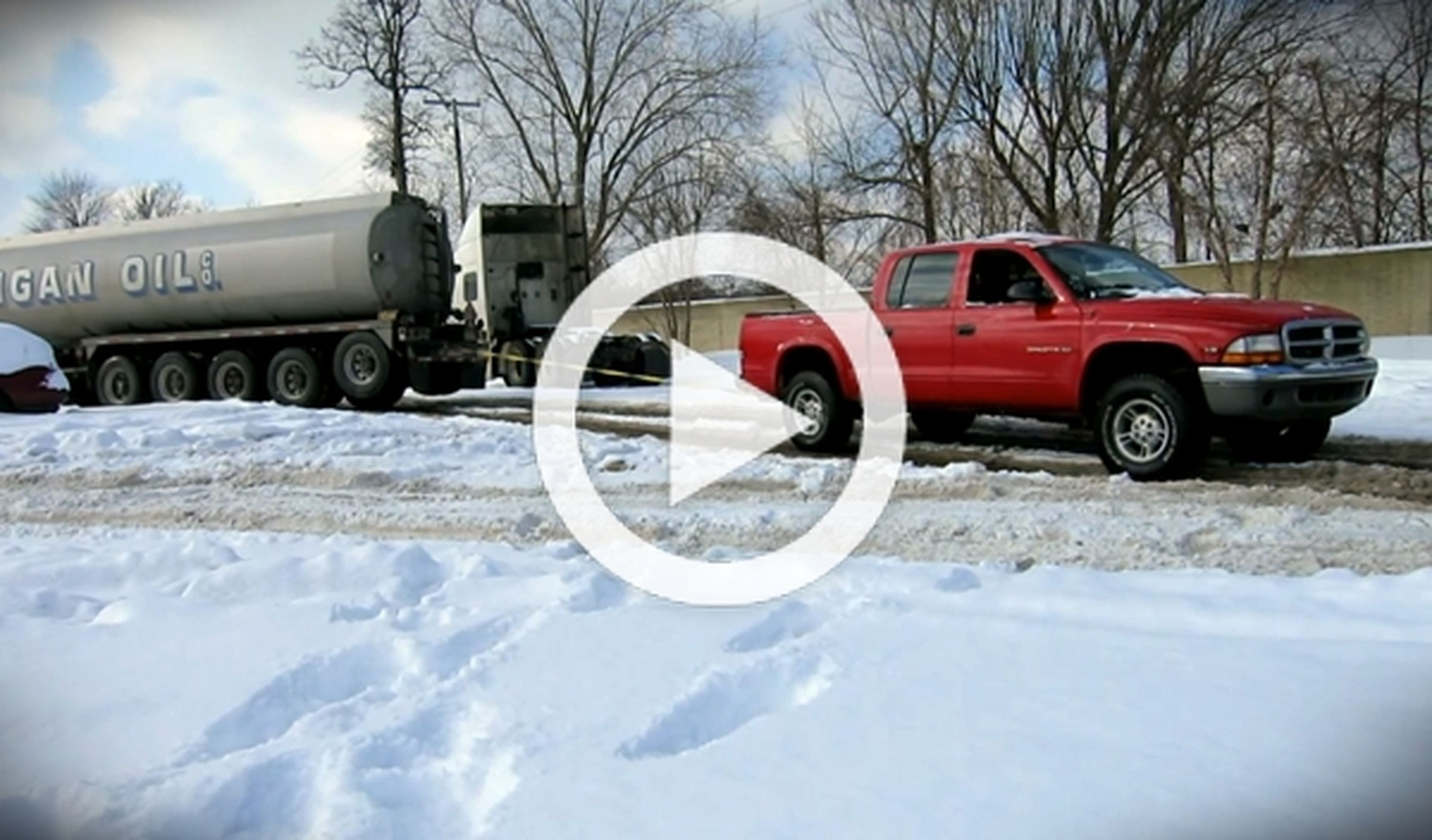 Una pick-up remolca a un camión en la nieve