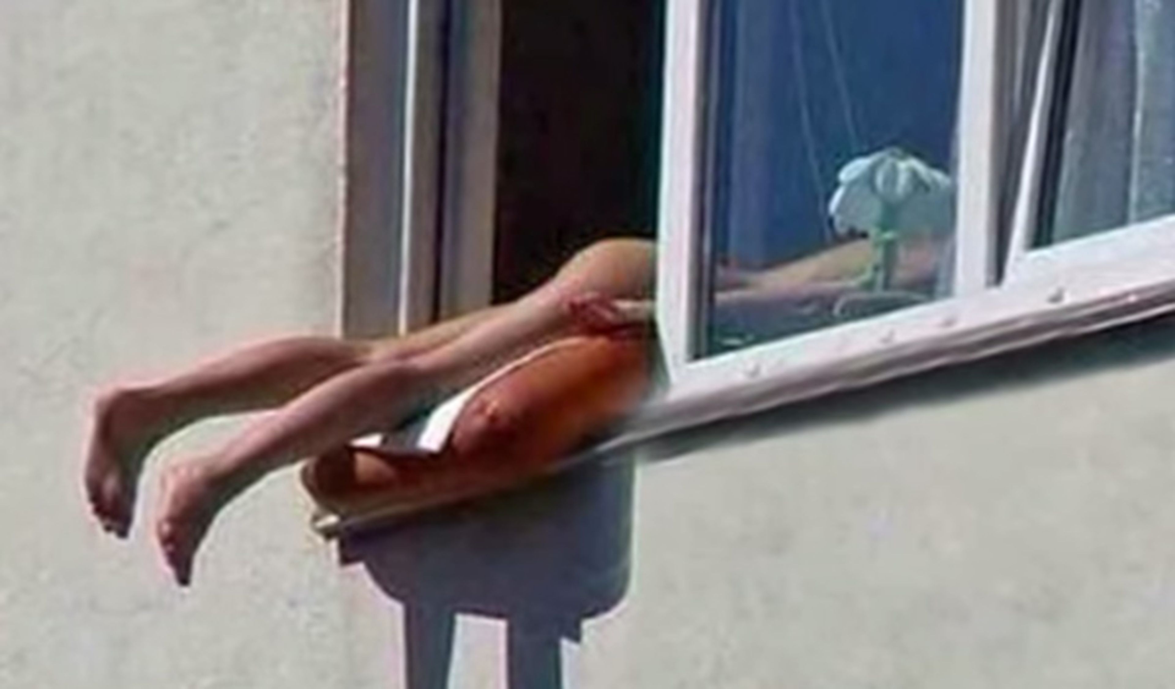 Provoca un accidente por tomar el sol desnuda en la ventana