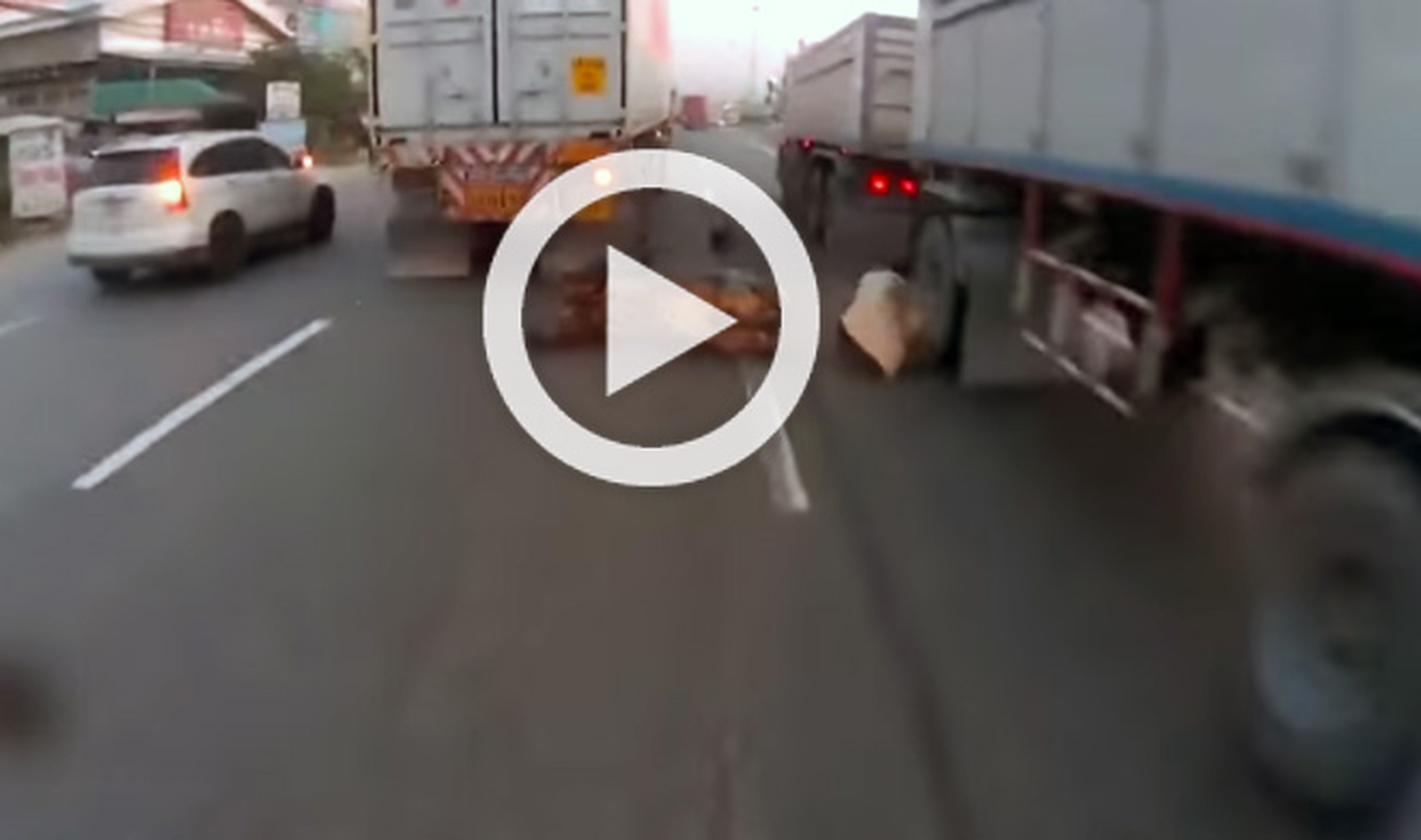 Este motorista evita ser atropellado por dos camiones