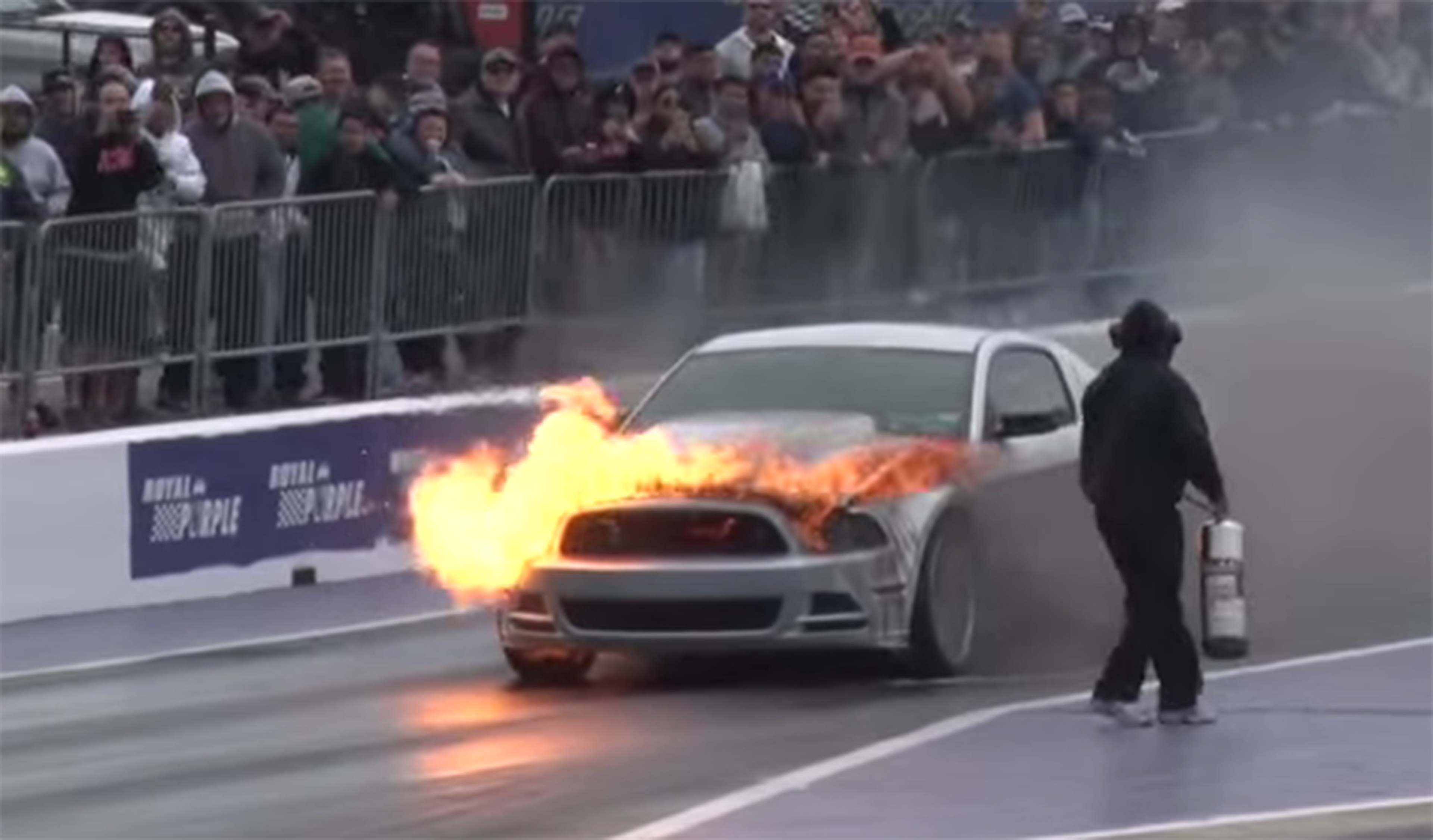 Un Ford Mustang envuelto en llamas en una drag race