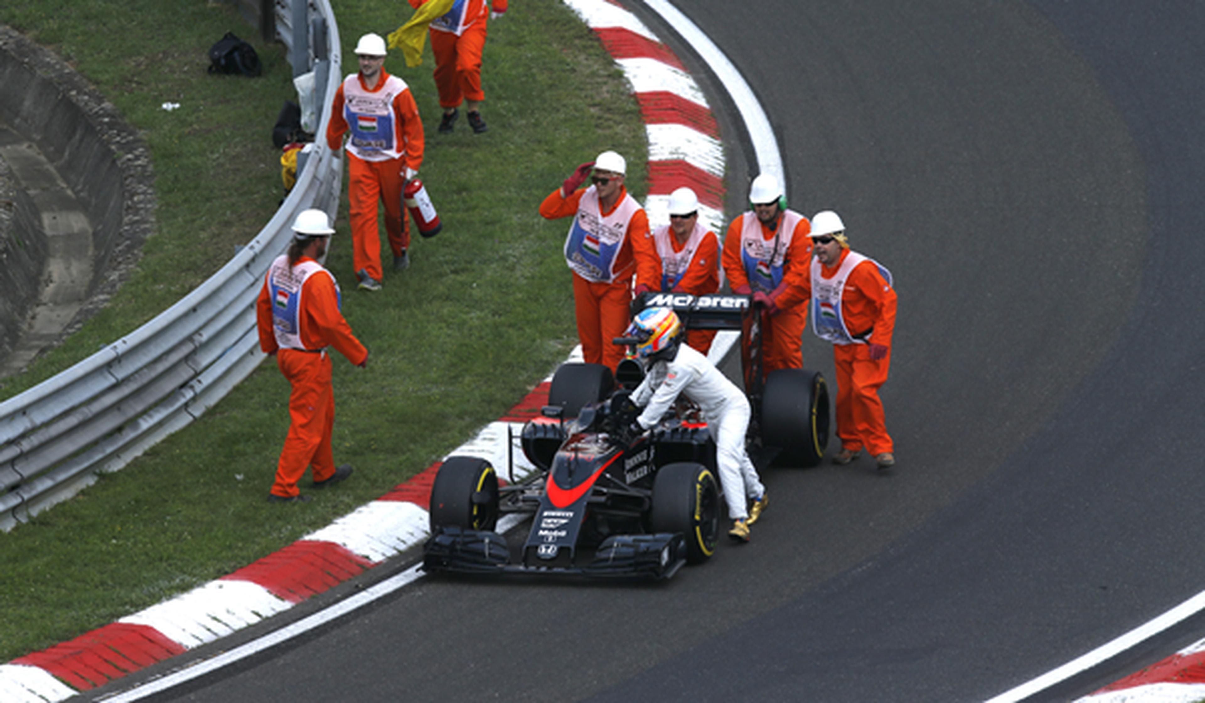 Alonso empuja su coche hasta el pit lane en Hungría