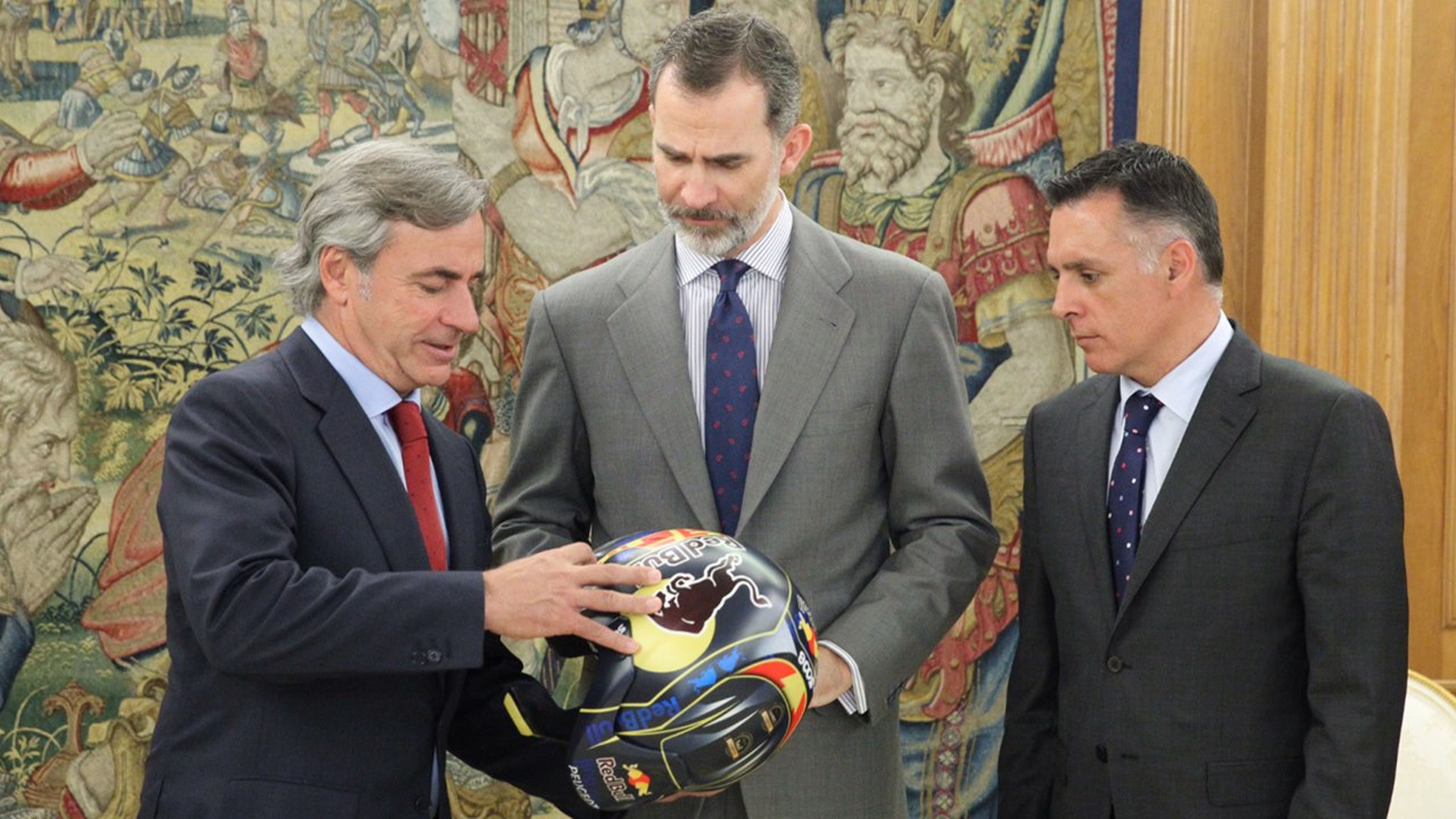 Carlos Sainz entrega un casco al rey