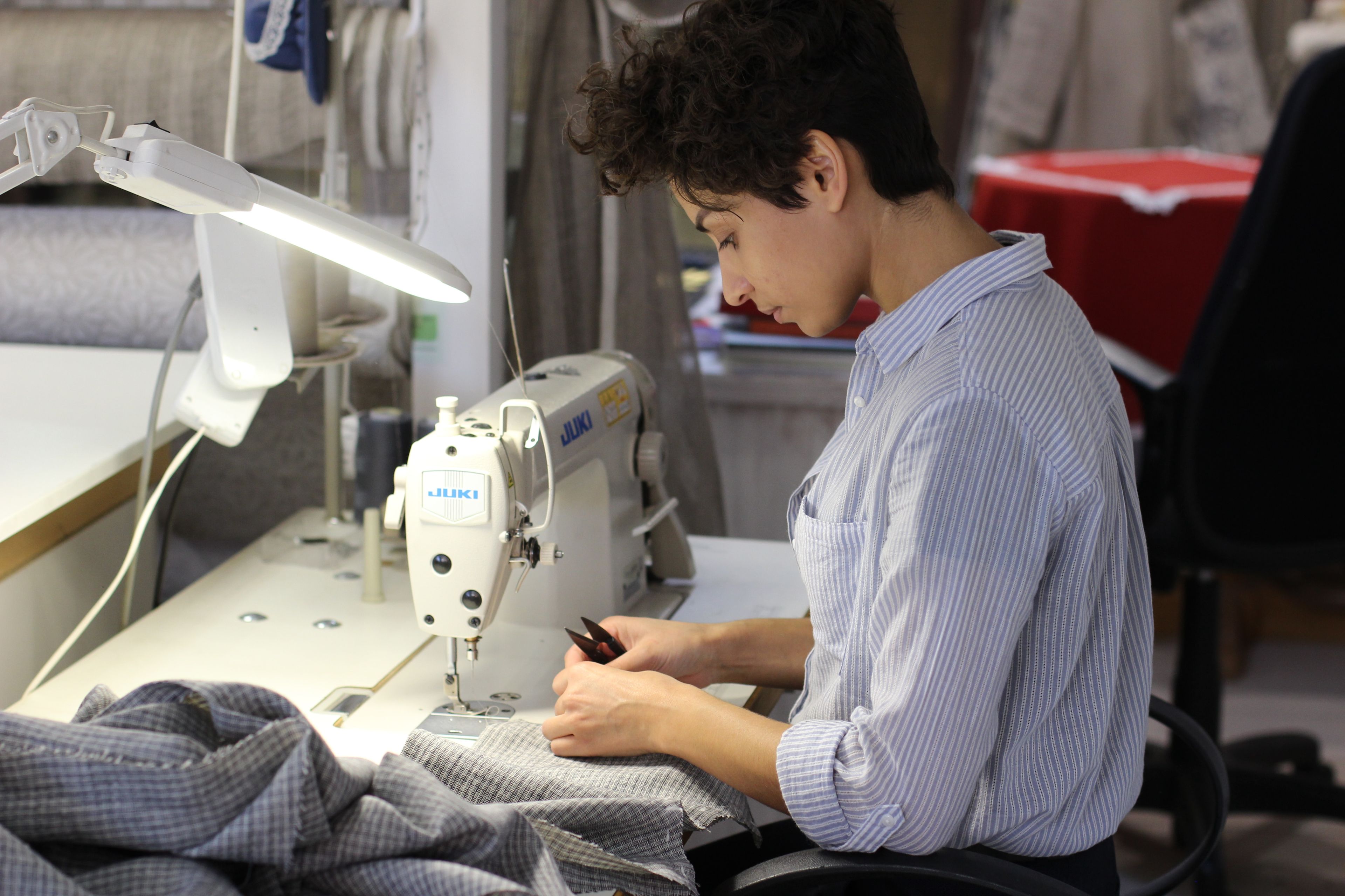 costurera, mujer cosiendo ropa con máquina de coser