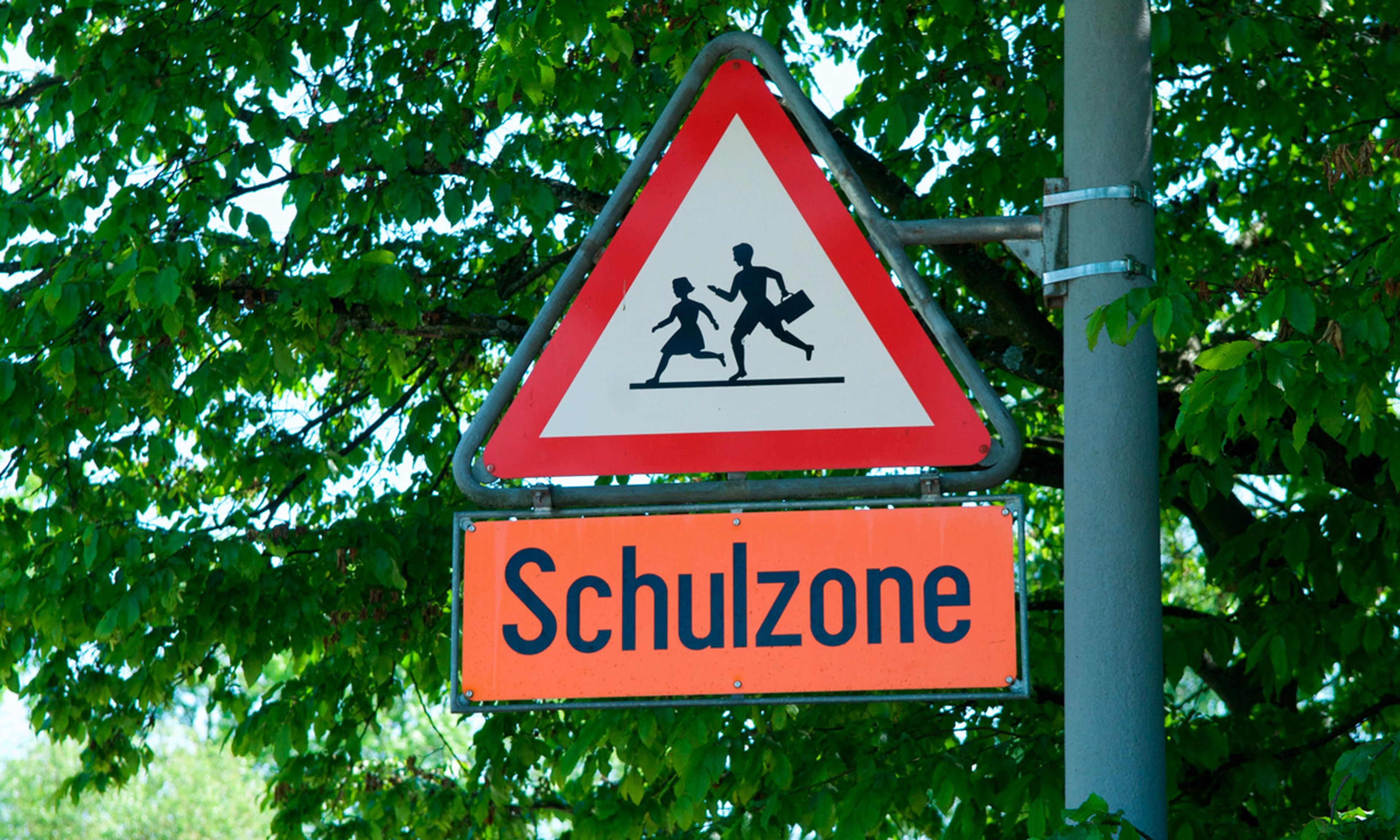 Ciertamente, la señal de colegio en Alemania es igual de antigua y muestra a una niña delante de un hombre