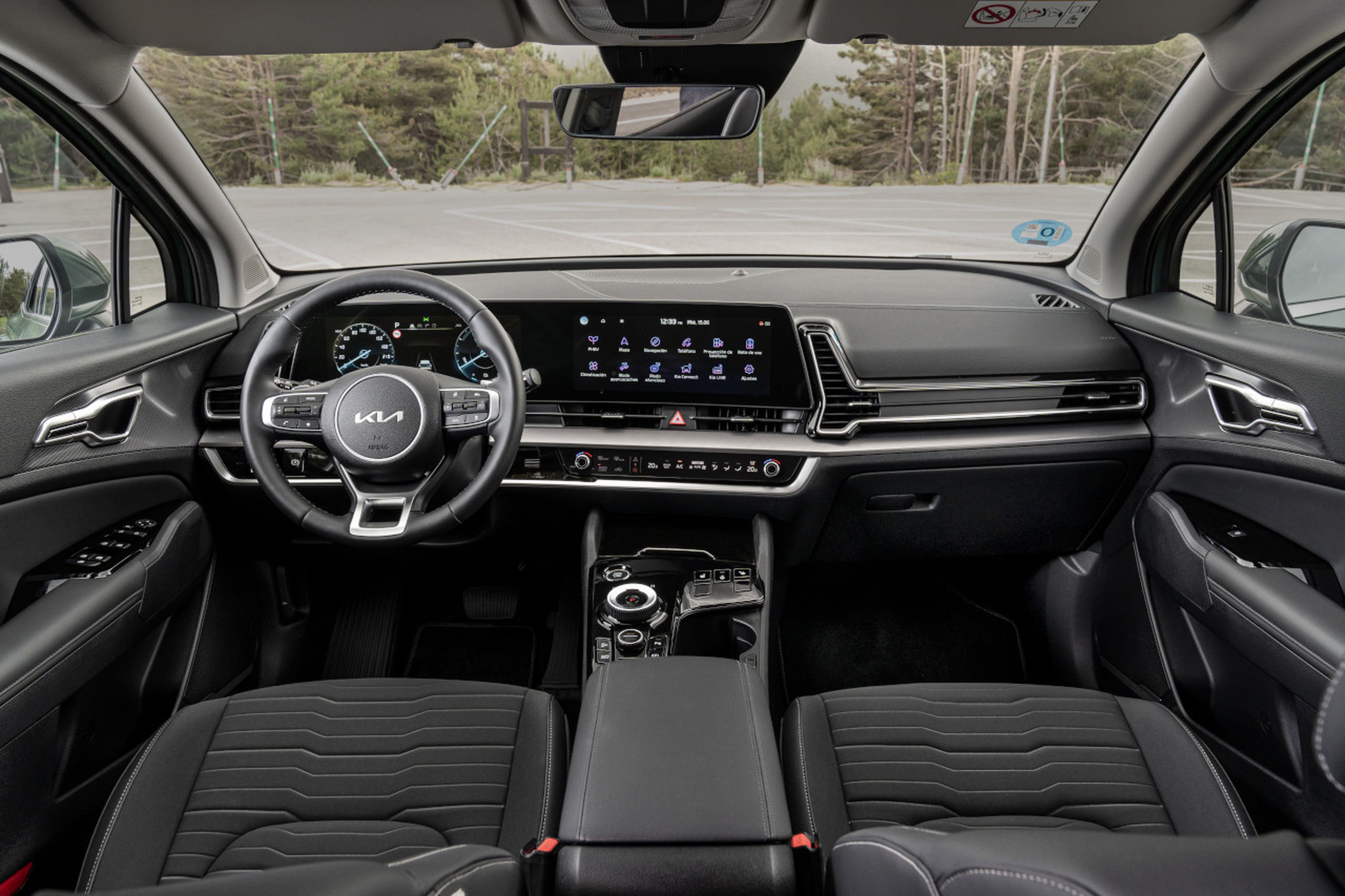 Interior del Kia Sportage PHEV con la enorme pantalla curvada compuesta por sistema de infontainment e instrumentación.